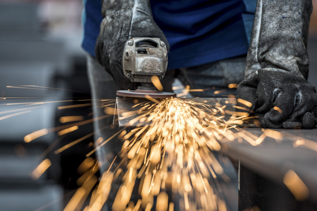 Industrial Worker Cutting Metal With Many Sharp Sparks